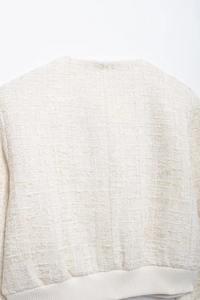 Détail de la texture en tweed blanc de qualité et de l'ourlet côtelé de la veste
