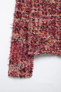 Close-up of multicolor textured knit fabric with fringe edges and premium yarn detail