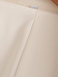 Detail view of smooth cream quilted jacket lining with satin finish and hanger loop