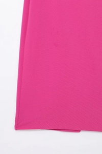 Close-up detail of hot pink midi dress fabric with premium pleated texture and neat hemline
