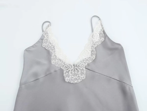 Detail of the delicate white floral lace trim on the grey satin camisole v-neckline