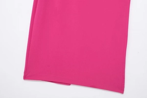 Macro detail of the pleated hem and fine stitching on the fuchsia midi dress fabric