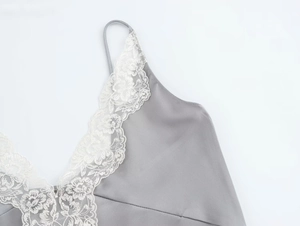 Close-up of gray satin camisole featuring delicate white lace trim and thin straps