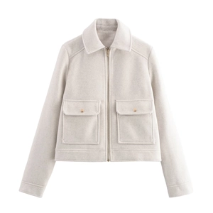 Détail d'une veste courte beige avec fermeture éclair et poches à rabat et boutons dorés