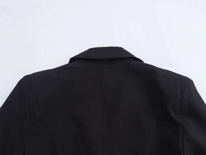 Detail view of the notch lapel and shoulder tailoring on a black business blazer jacket