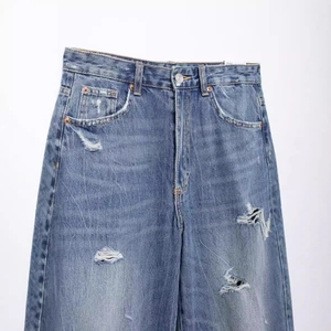 Women's high waist ripped balloon jeans in washed blue with retro distressed details