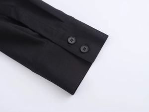 Detail of black shirt dress double-button cuffs with neat stitching and smooth fabric