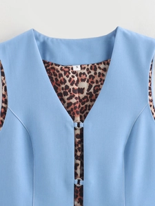 Detailed view of women's denim vest with trendy leopard print lining and metal buckle