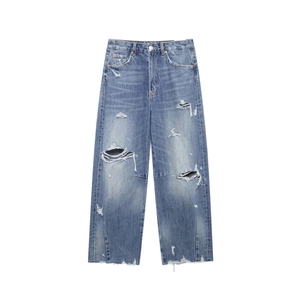 High-waisted loose fit distressed blue denim jeans with vintage ripped details and raw hem