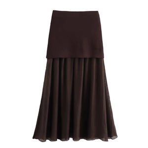 Detail of chocolate brown knit maxi skirt featuring a pleated chiffon patchwork hemline
