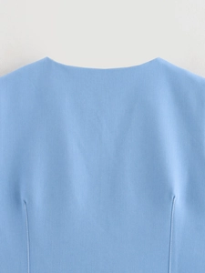 Detailed view of sky blue denim vest neckline featuring white contrast stitching