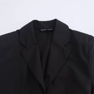 Close-up of black long-sleeved shirt dress collar with brand label and waist belt detail