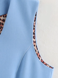 Close-up of light blue denim vest with stylish leopard print lining and quality stitching
