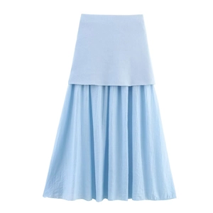 Detail of light blue knit skirt with layered patchwork hem and textured fabric finish