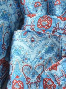 Vue détaillée de l'imprimé paisley et du matelassage en losanges de cette veste bleue