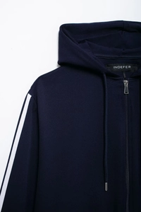 Detail of navy blue hoodie featuring side stripes and polished silver zipper hardware