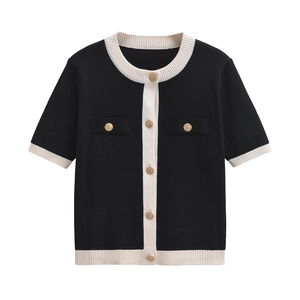 Detailed view of black short-sleeved knit cardigan with white trim and gold buttons