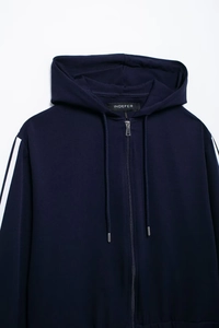 Detailed close-up of navy blue zip-up hoodie with white double stripes on sleeves