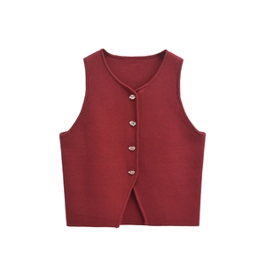 Detail of dark red knit vest showing V-neck and silver metallic buttons on textured fabric