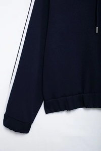 Detail of navy track jacket with white side stripes and ribbed cuffs for women