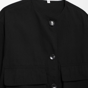 Veste noire pour femme avec col rond, grandes poches à rabat et fermeture à boutons