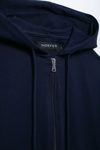 Detail of navy blue zip-up hoodie showing silver zipper and soft knit fabric texture