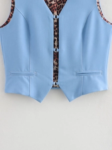 Detail view of denim vest featuring leopard print lining and silver ring buckle closure