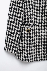 Detailed macro view of black and white houndstooth tweed texture and embossed button