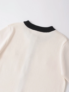Detail shot of off-white knitted cardigan neck with contrasting black ribbed trim