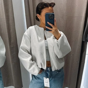 Giacca da donna oversize grigio chiaro con zip e spalle scese in perfetto stile streetwear
