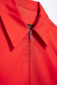 Close-up of red lapel jacket featuring silver metal zipper and premium fabric texture