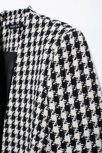 Close-up of black and white houndstooth wool fabric texture and sleek inner lining