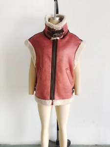 Détail de veste en daim rose avec doublure en peau de mouton et col montant à doubles boucles