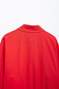 Close-up of bright red zip-up jacket showing smooth fabric texture and stand collar