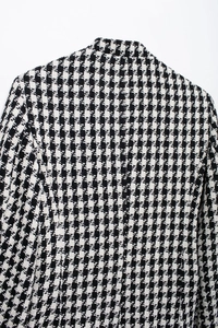 Detailed back view of the black and white houndstooth tweed jacket shoulder and collar area