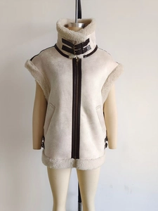 Détail du col montant avec boucles en cuir marron sur le gilet en polaire crème
