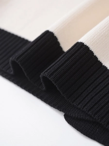 Close-up of black ribbed cuff texture and two-tone knit stitching on the cardigan sleeve