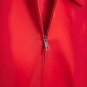 Women's red autumn jacket detail featuring a high-quality metal zipper and twill fabric