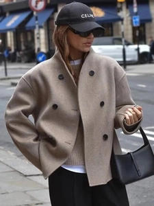 Detail of oatmeal double-breasted wool coat with large lapels and urban street style look