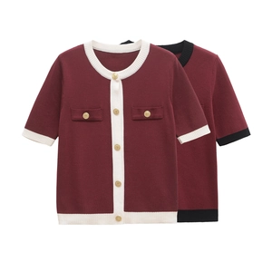 Detail of burgundy knit cardigan with contrast trim and decorative gold buttons