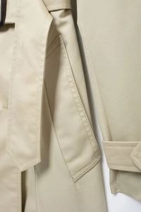 Detailed macro view of beige trench coat waist belt and twill fabric texture details