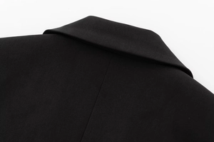 Detail shot of black blazer collar showing premium twill fabric texture and neat stitching
