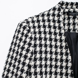 Classic black and white houndstooth wool coat with elegant lapel and brand label detail