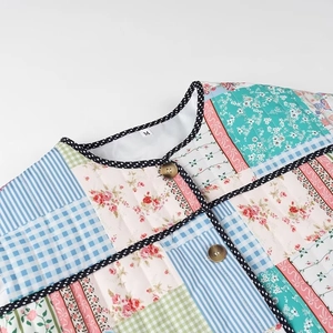 Close-up of quilted patchwork jacket with floral patterns and dotted neckline detail