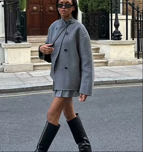 Close-up of double-breasted grey wool blend coat with high collar and dark round buttons