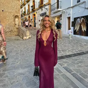 Detail of burgundy knit dress with deep V-neck and decorative gold metal ring