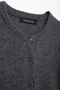 Detailed macro view of dark grey knit cardigan neckline with ribbed trim and three buttons