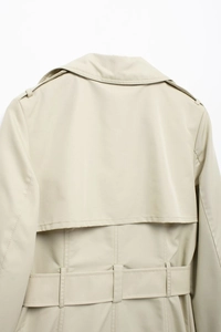 Detailed back view of a khaki trench coat featuring a storm flap and matching belt