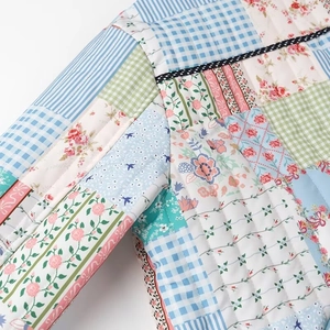 Detail of patchwork quilted cotton coat with colorful floral and stripe patterns