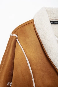 Close-up of brown faux suede jacket featuring white shearling trim and contrast stitching